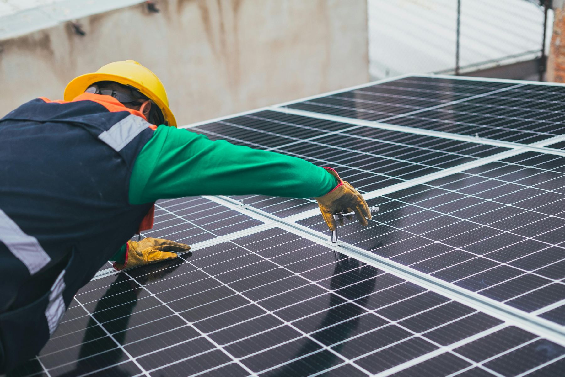 Solar technician installing rooftop solar panels