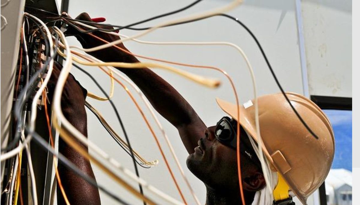 Electrician installing domestic wiring in a ceiling access area