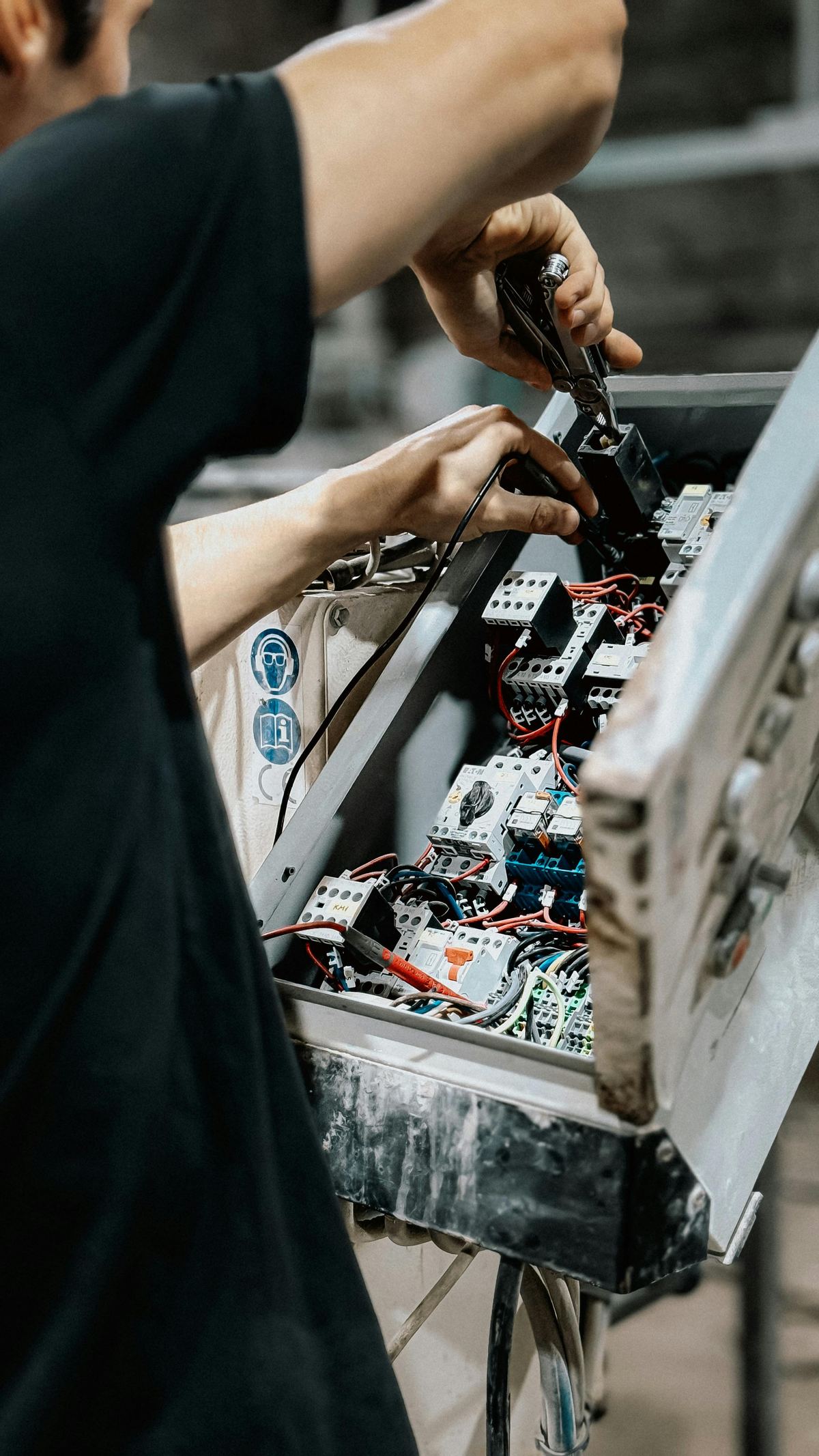 Technician working on an industrial electrical control panel